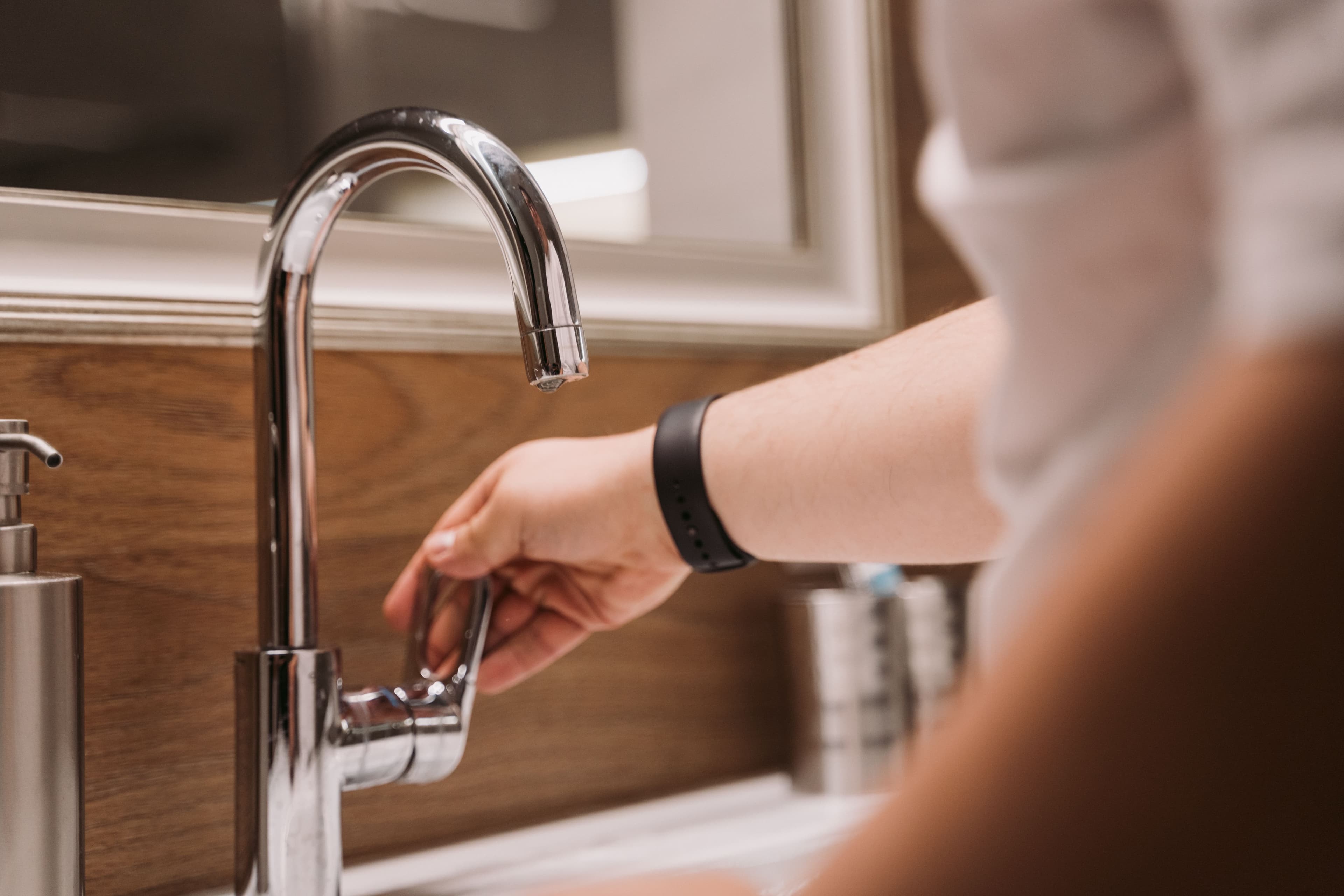 Plumber adjusting a bathroom faucet during a residential service call